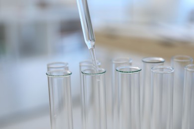 Photo of Laboratory analysis. Dripping liquid into test tubes indoors, closeup