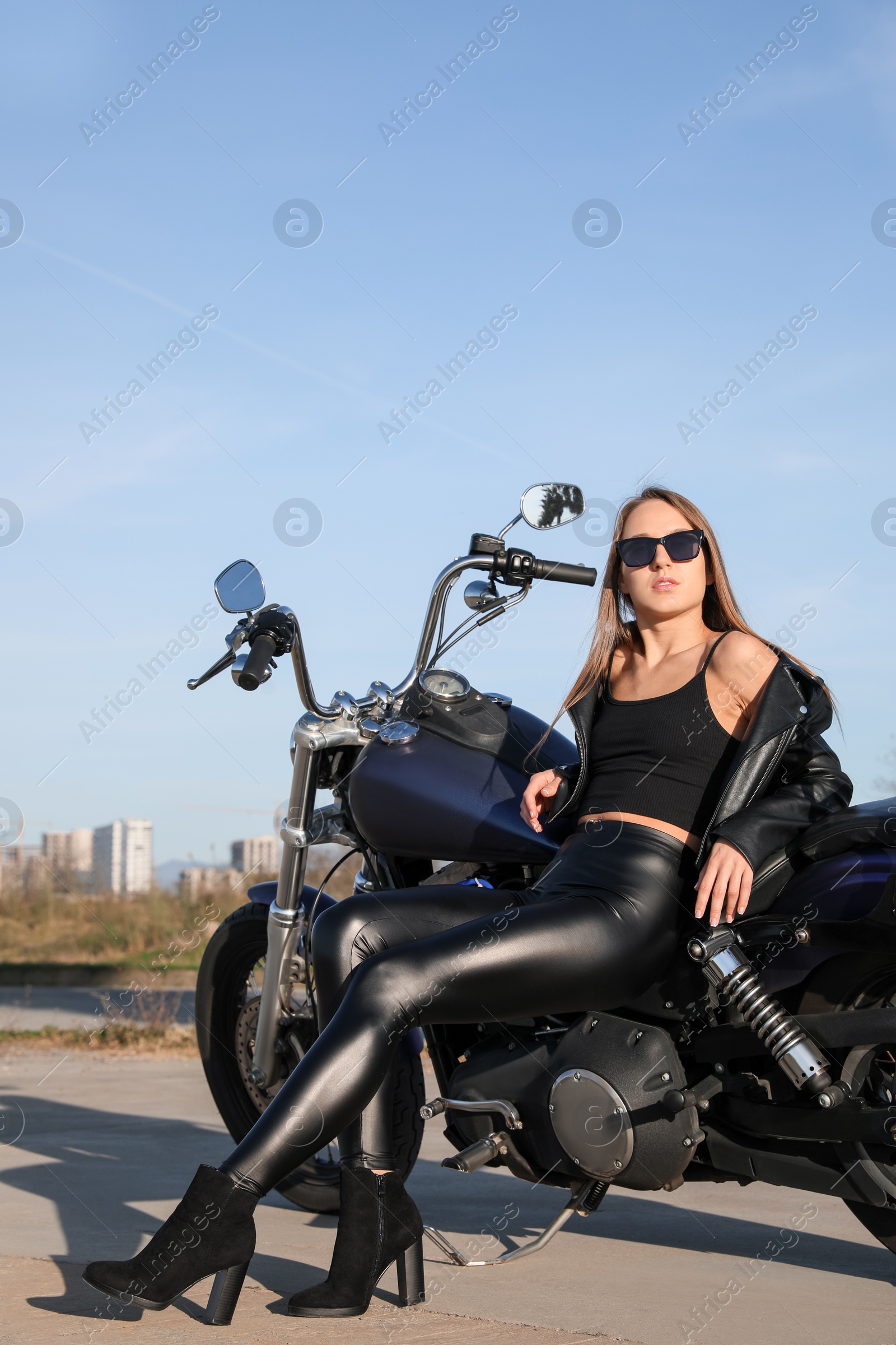 Photo of Beautiful young woman sitting on motorcycle outdoors