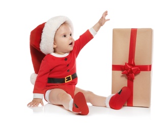 Cute little baby in Christmas costume and gift on white background