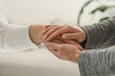 Photo of Trust and support. Men joining hands on blurred background, closeup