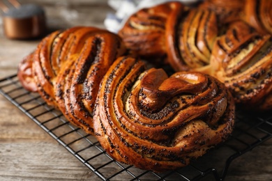 Photo of Tasty sweet buns with poppy seeds on wooden table