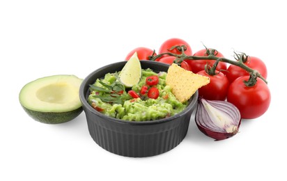 Delicious guacamole with nachos chips, lime and different ingredients isolated on white