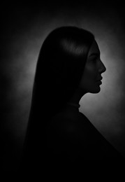 Image of Silhouette of woman in darkness. Portrait on black background