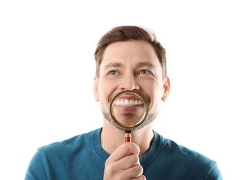 Photo of Smiling man with perfect teeth and magnifier on white background