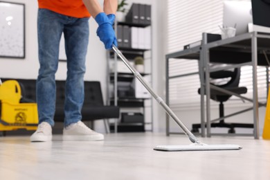 Cleaning service. Man washing floor with mop, closeup