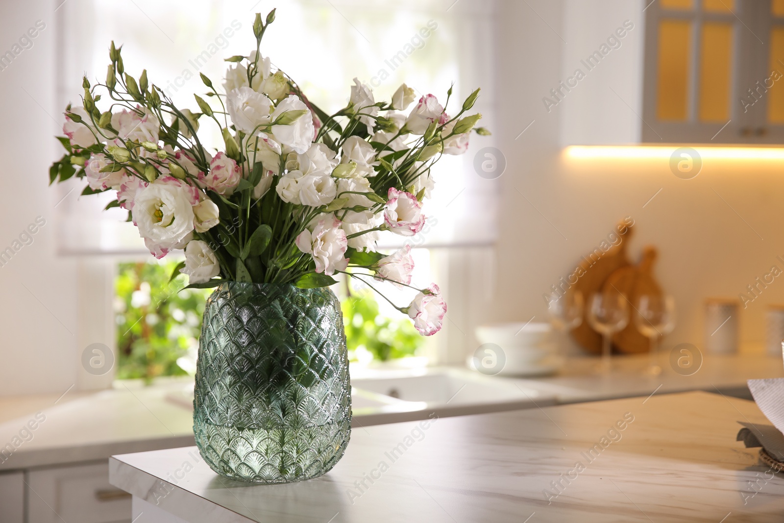 Photo of Bouquet of beautiful flowers on countertop in kitchen, space for text. Interior design