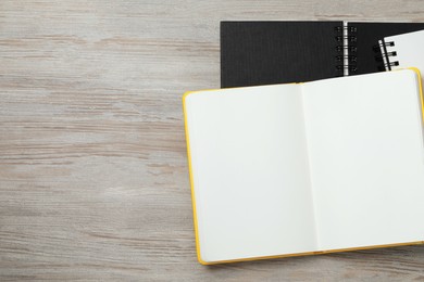 Stylish notebooks on white wooden table, flat lay. Space for text