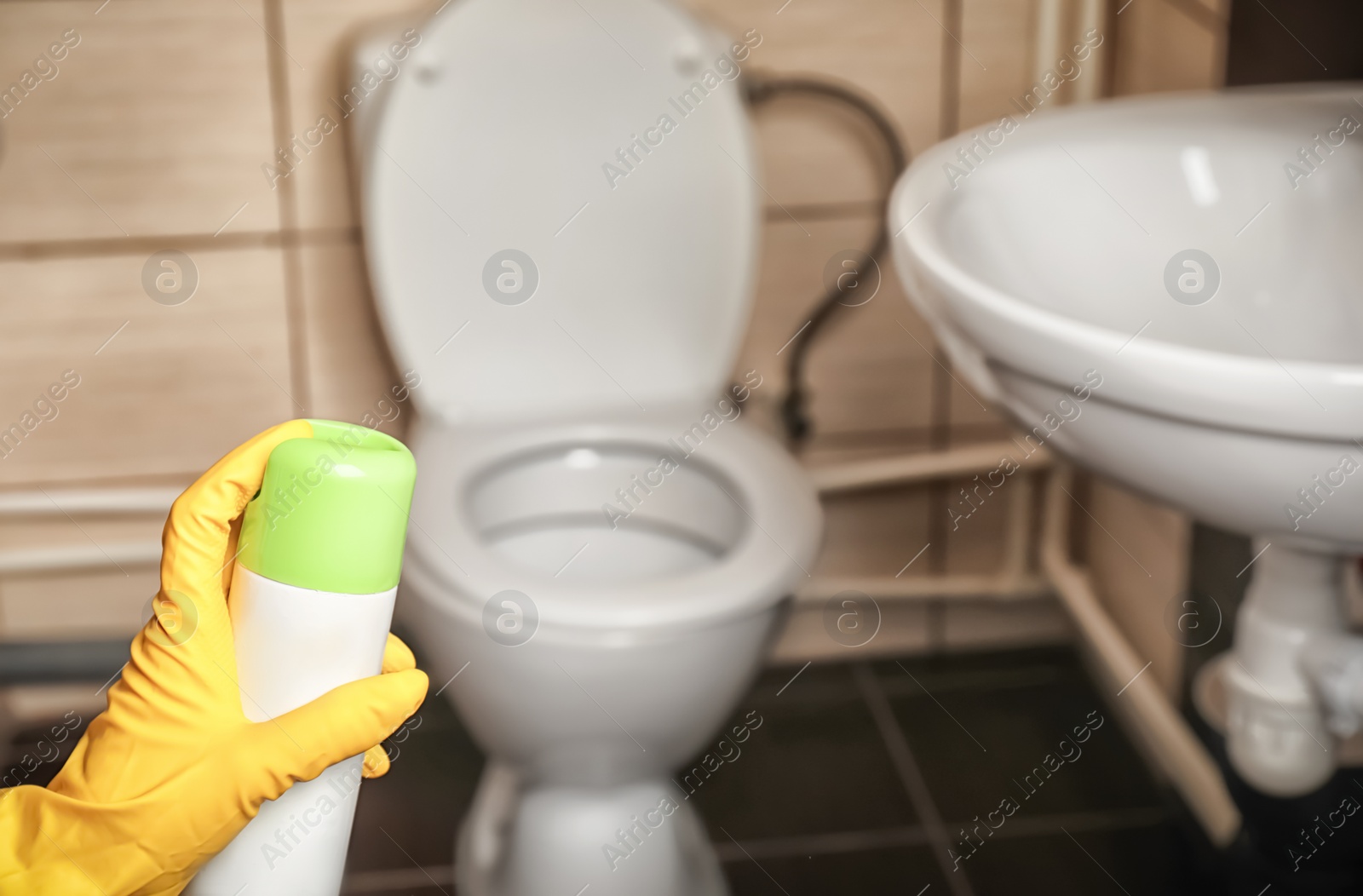 Photo of Person spraying air freshener in bathroom