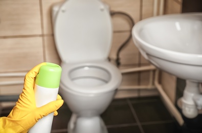 Photo of Person spraying air freshener in bathroom