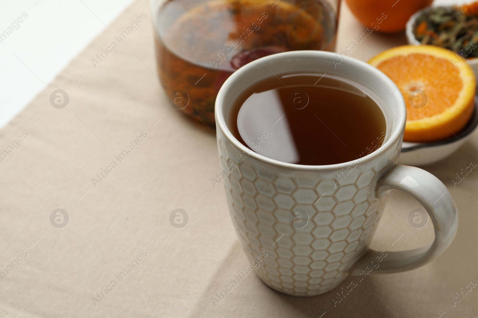 Photo of Cup of aromatic herbal tea on table, space for text