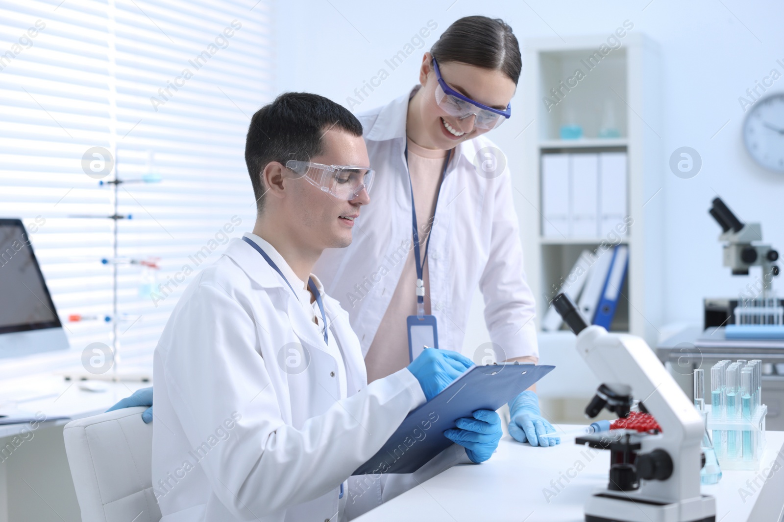 Photo of Scientists working with laboratory test form at table indoors