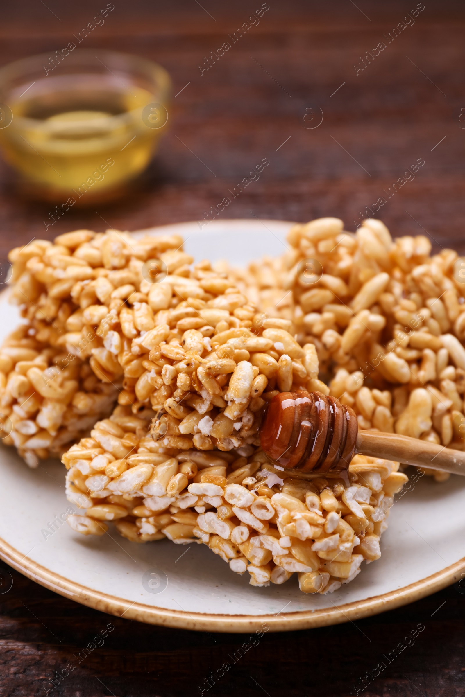 Photo of Plate with puffed rice bars (kozinaki) on wooden table, closeup