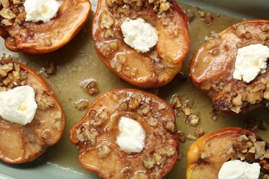 Tasty baked quinces with nuts and cream cheese in dish, top view