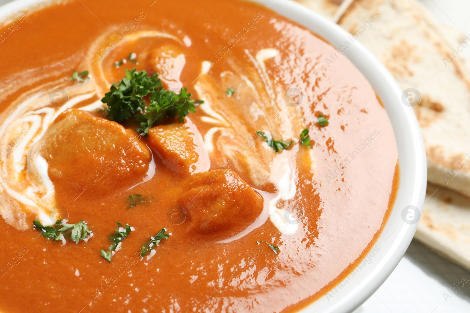 Photo of Delicious butter chicken in bowl, closeup. Traditional Murgh Makhani dish