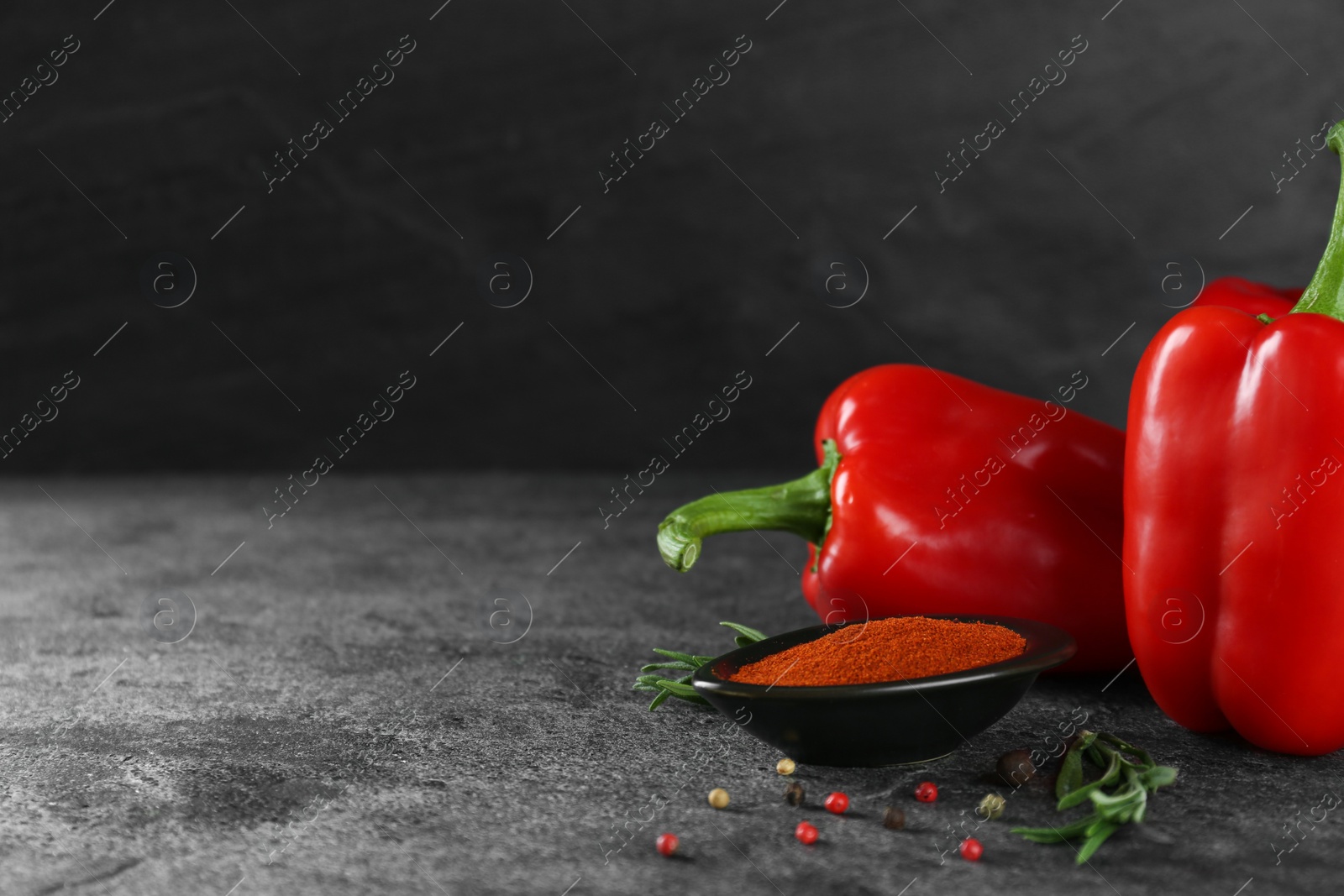 Photo of Dish of paprika with ingredients on grey table. Space for text