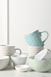 Photo of Beautiful ceramic dishware and cups on white table