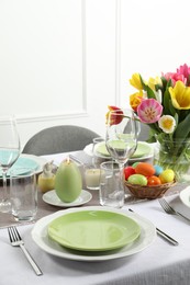 Photo of Easter celebration. Festive table setting with beautiful flowers and painted eggs