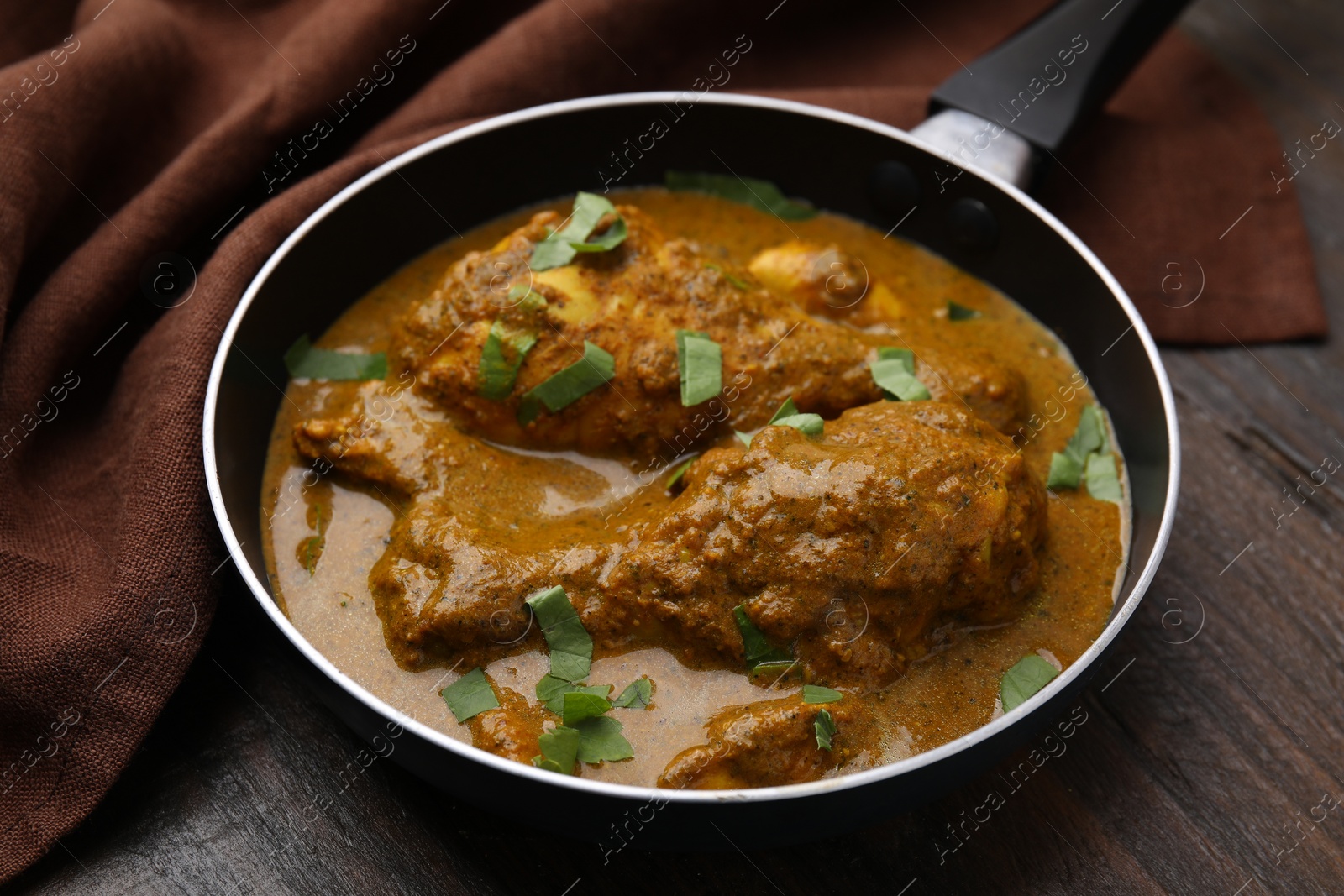 Photo of Delicious chicken with curry sauce on wooden table, closeup