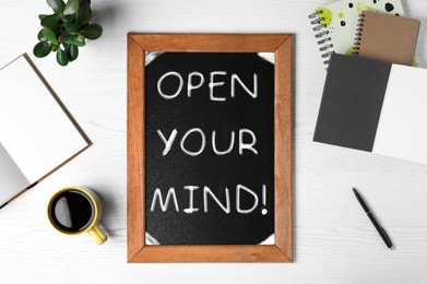 Small chalkboard with motivational quote Open your mind, coffee, plant and stationery on white wooden table, flat lay