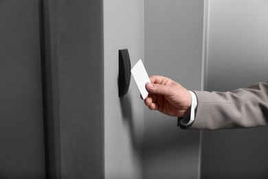 Photo of Man opening magnetic door lock with key card, closeup. Home security