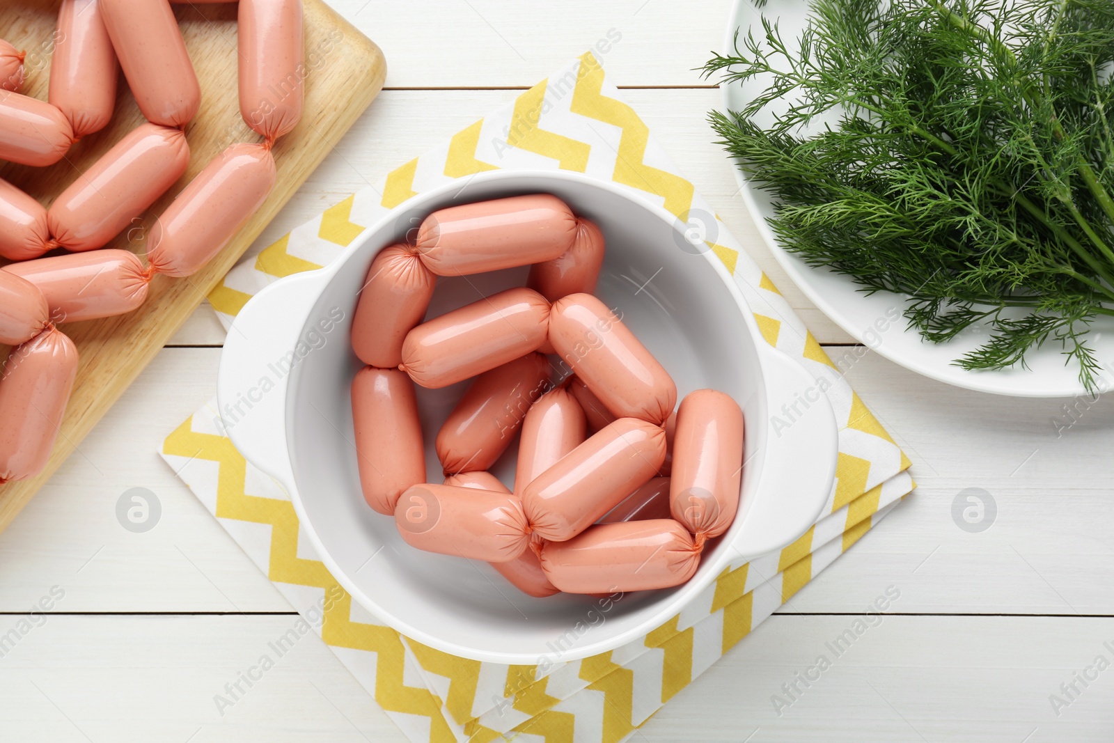 Photo of Delicious sausages and dill on white wooden table, flat lay