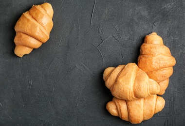 Tasty croissants on dark background, top view