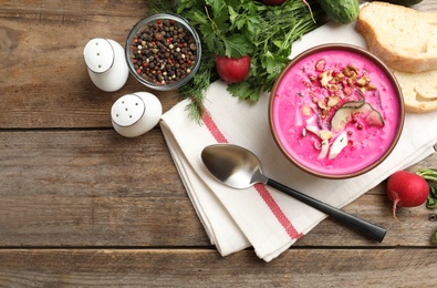 Photo of Delicious cold summer beet soup on wooden table, flat lay. Space for text