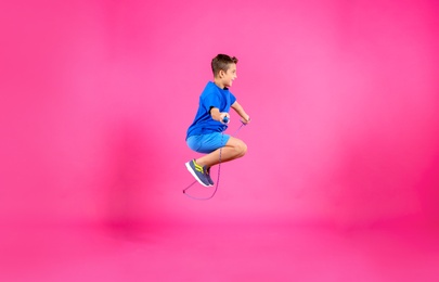 Photo of Active boy jumping rope on color background