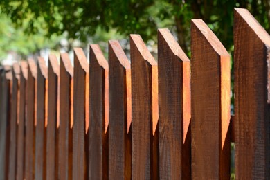 Photo of Wooden fence on sunny day outdoors, closeup