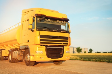 Photo of Modern yellow truck on country road. Space for text