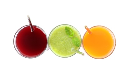 Photo of Delicious colorful juices in glasses isolated on white, top view
