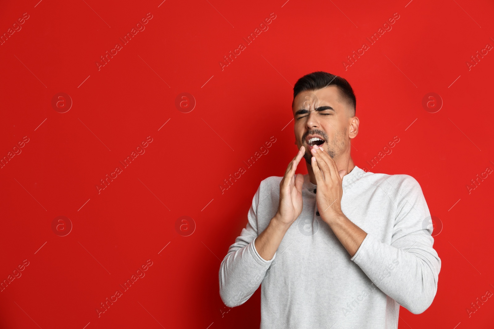 Image of Man sneezing on red background, space for text. Cold symptoms