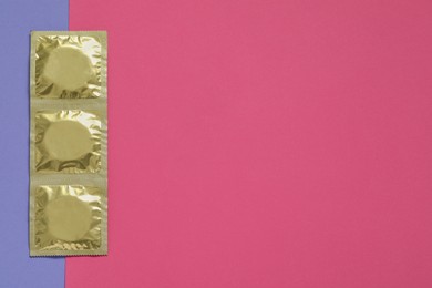 Condom packages on color background, flat lay and space for text. Safe sex