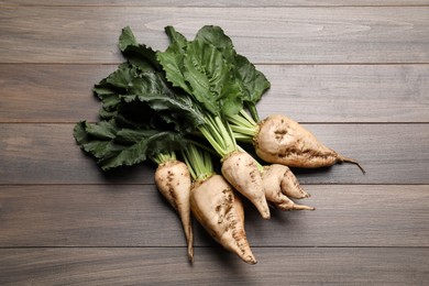 Fresh sugar beets with leaves on wooden table, flat lay