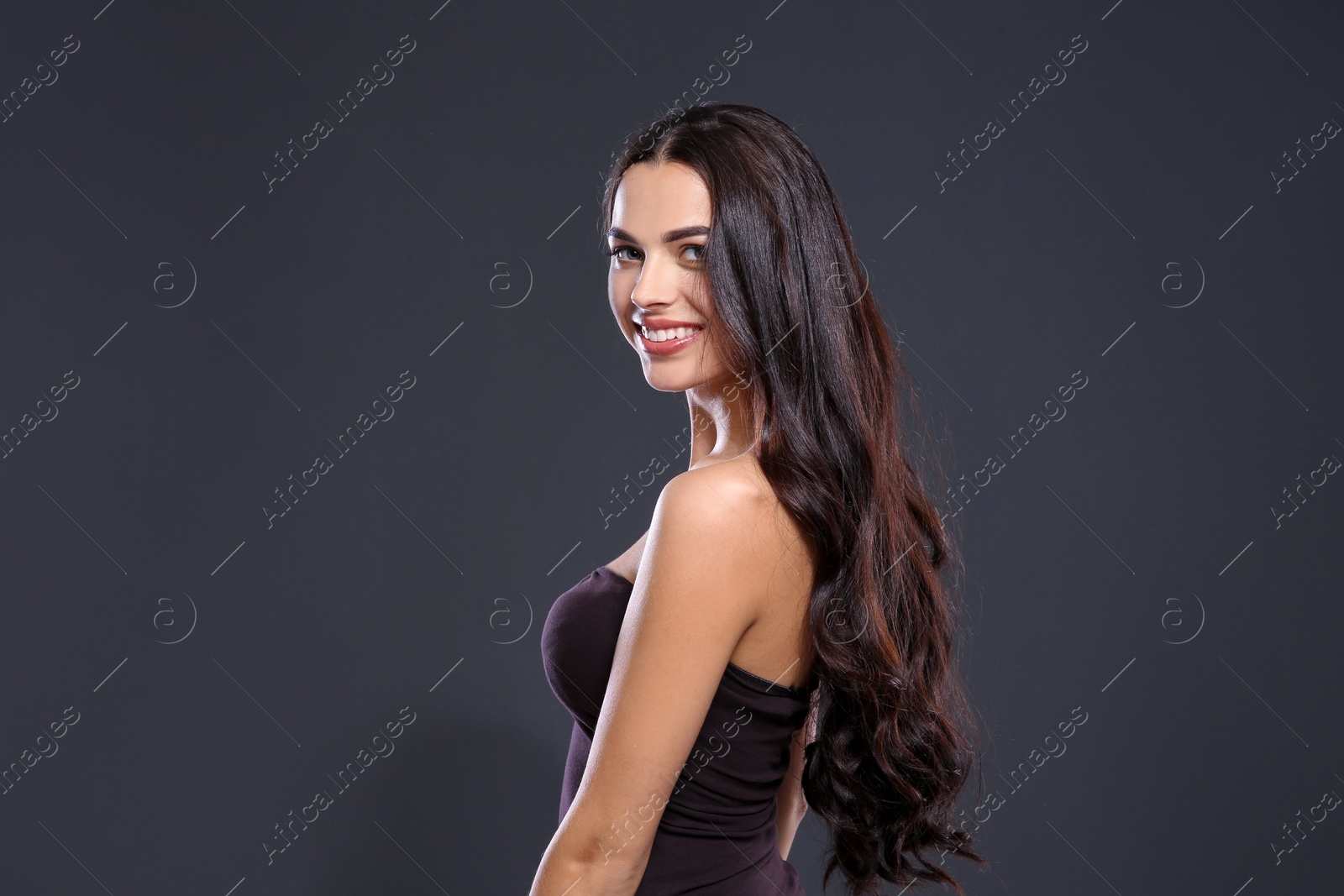 Photo of Portrait of beautiful model with gorgeous curly hair on black background