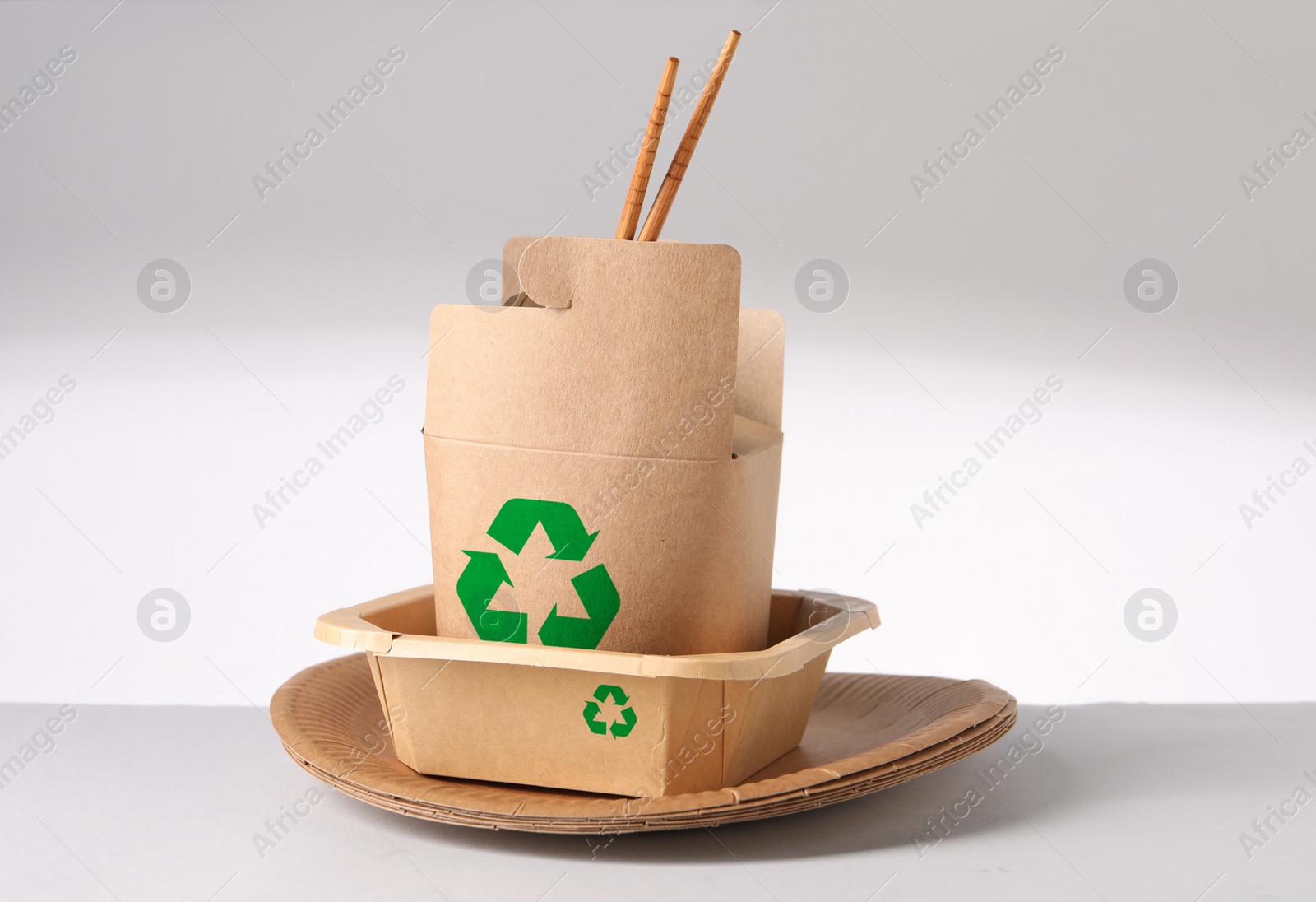 Image of Set of eco friendly food packaging with recycling symbols on light background