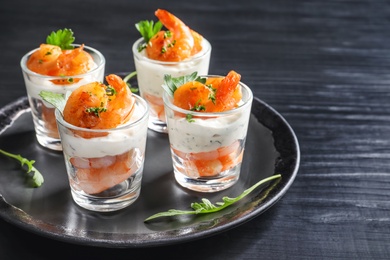 Photo of Glasses with fried shrimps and sauce on wooden background