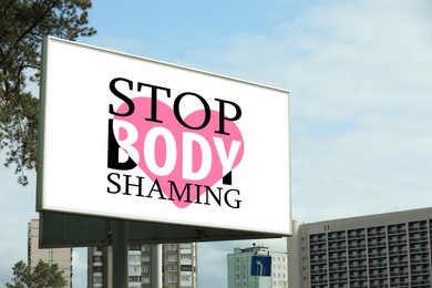 Image of Signboard with phrase Stop Body Shaming and pink heart on city street