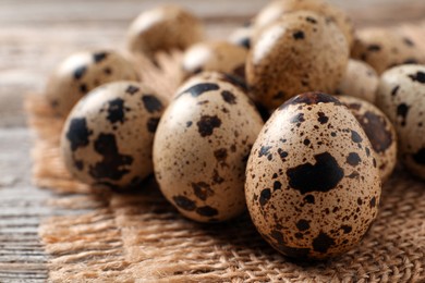 Photo of Fresh quail eggs on wooden table, closeup