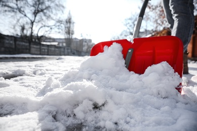 Photo of Person shoveling snow outdoors on winter day, closeup