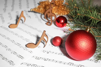 Composition with Christmas balls and wooden music notes on sheets