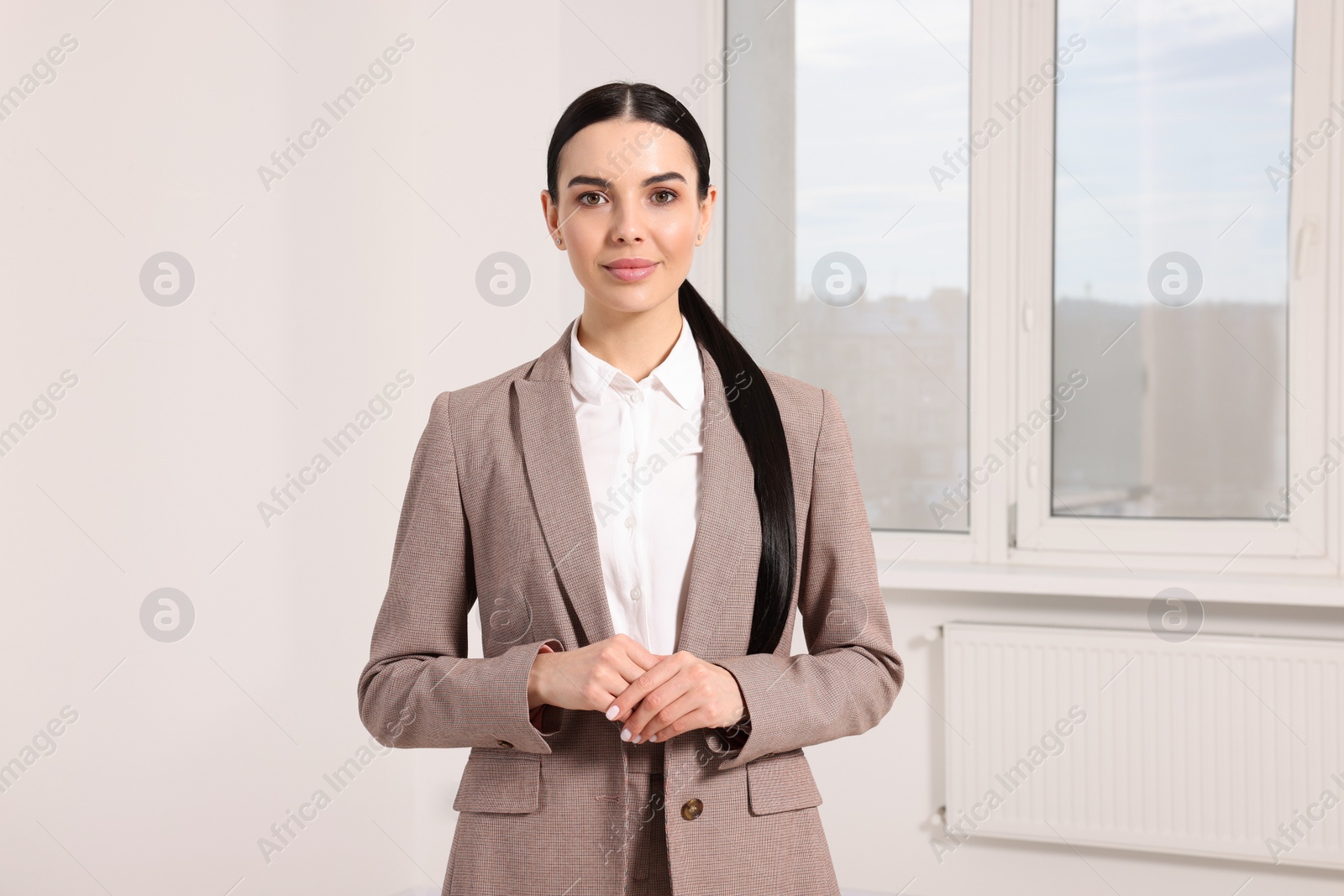 Photo of Beautiful real estate agent in nice suit indoors