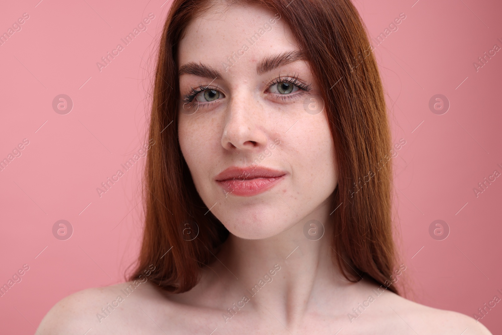 Photo of Portrait of beautiful woman with freckles on pink background, closeup