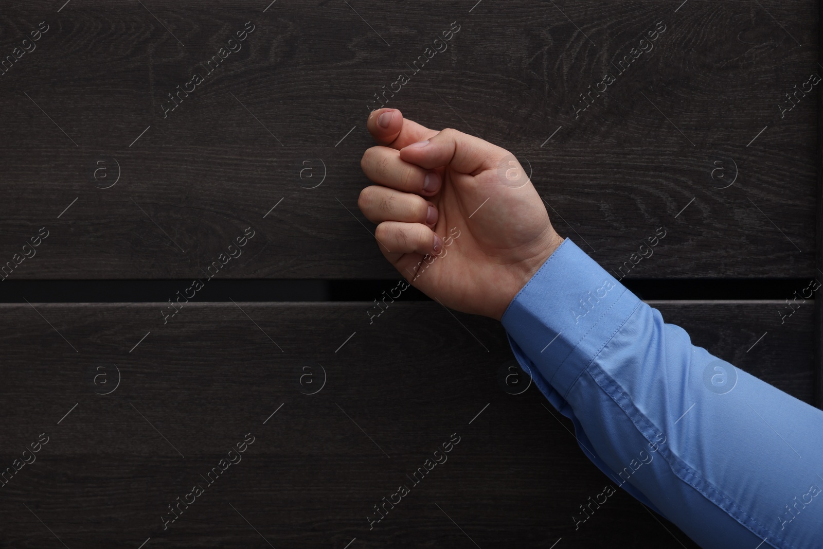 Photo of Collection agent knocking on wooden door, closeup