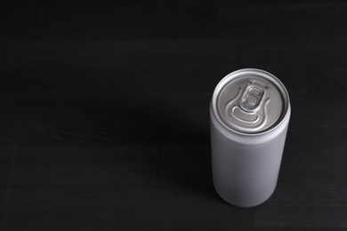 Photo of Energy drink in can on black wooden table