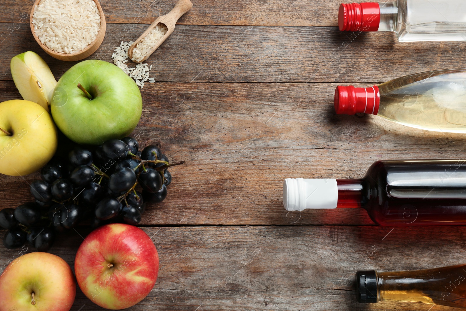 Photo of Flat lay composition with different kinds of vinegar and space for text on wooden background