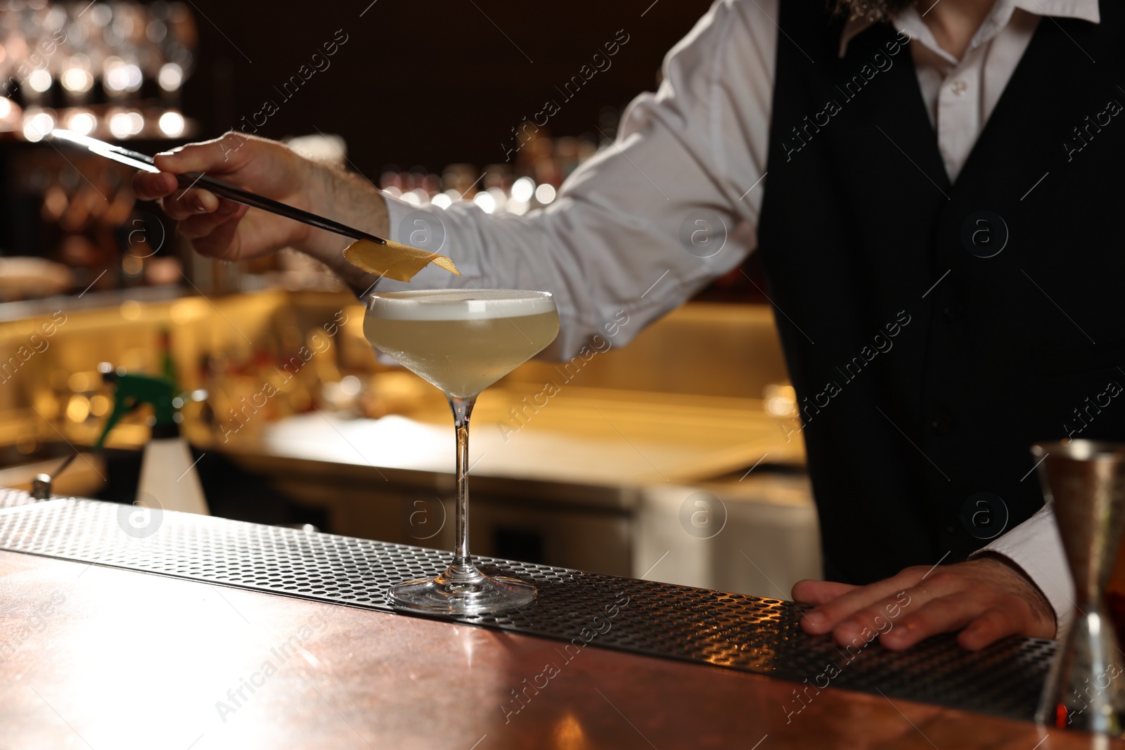 Photo of Bartender making fresh alcoholic cocktail at bar counter, closeup