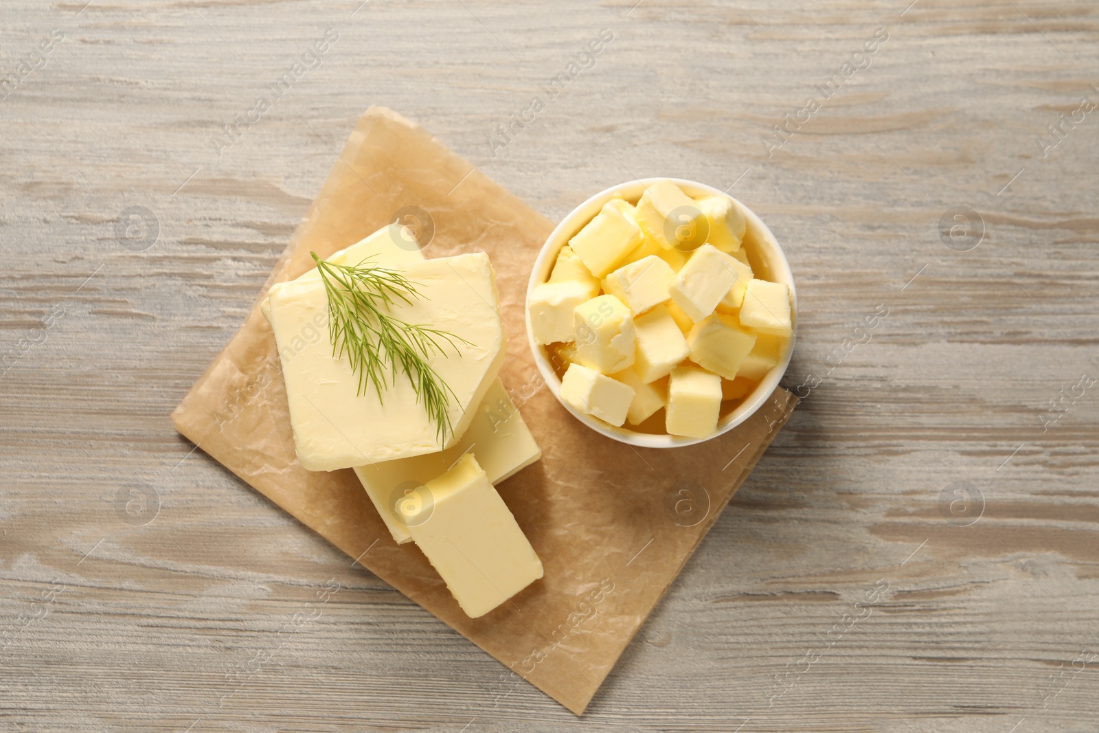 Photo of Tasty butter with dill on wooden table, top view