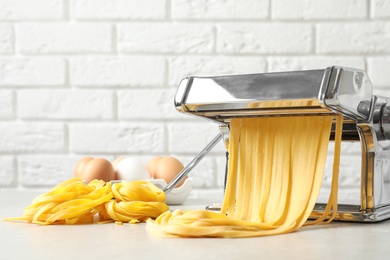 Pasta maker with dough on kitchen table