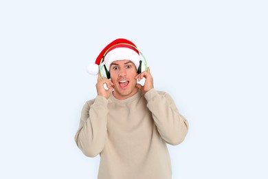 Photo of Emotional man with headphones on white background. Christmas music